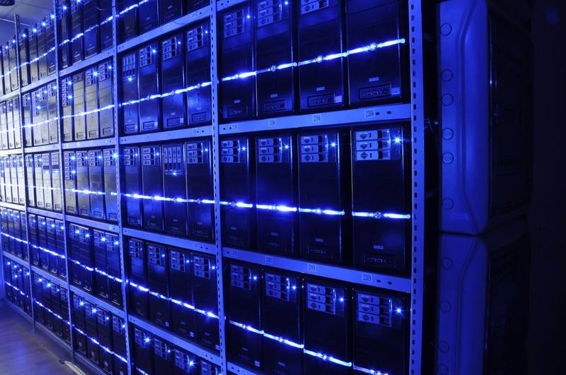 Редици сървъри, осветени от сини LED ленти в център за данни